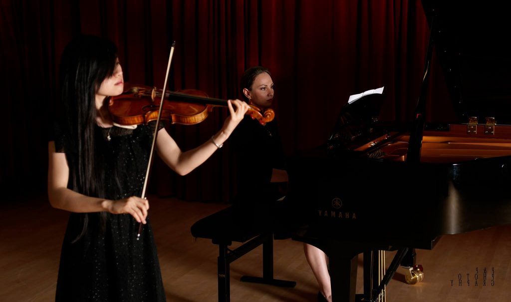 Image of pianist and violinist playing classical music together. Discover talented violin teachers with Musiprof.