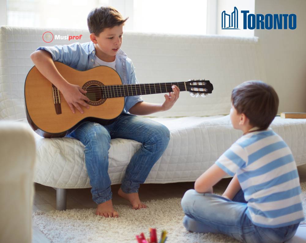 boy plays for his little brother. guitar lessons Toronto