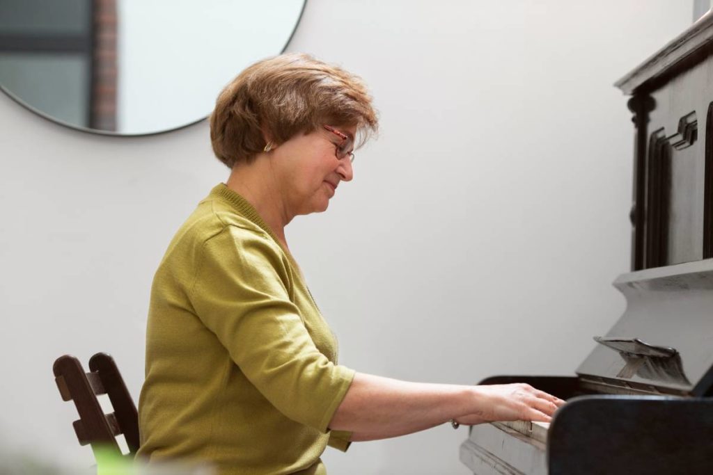 medium-shot-woman-playing-piano for her piano lessons for adults in Toronto