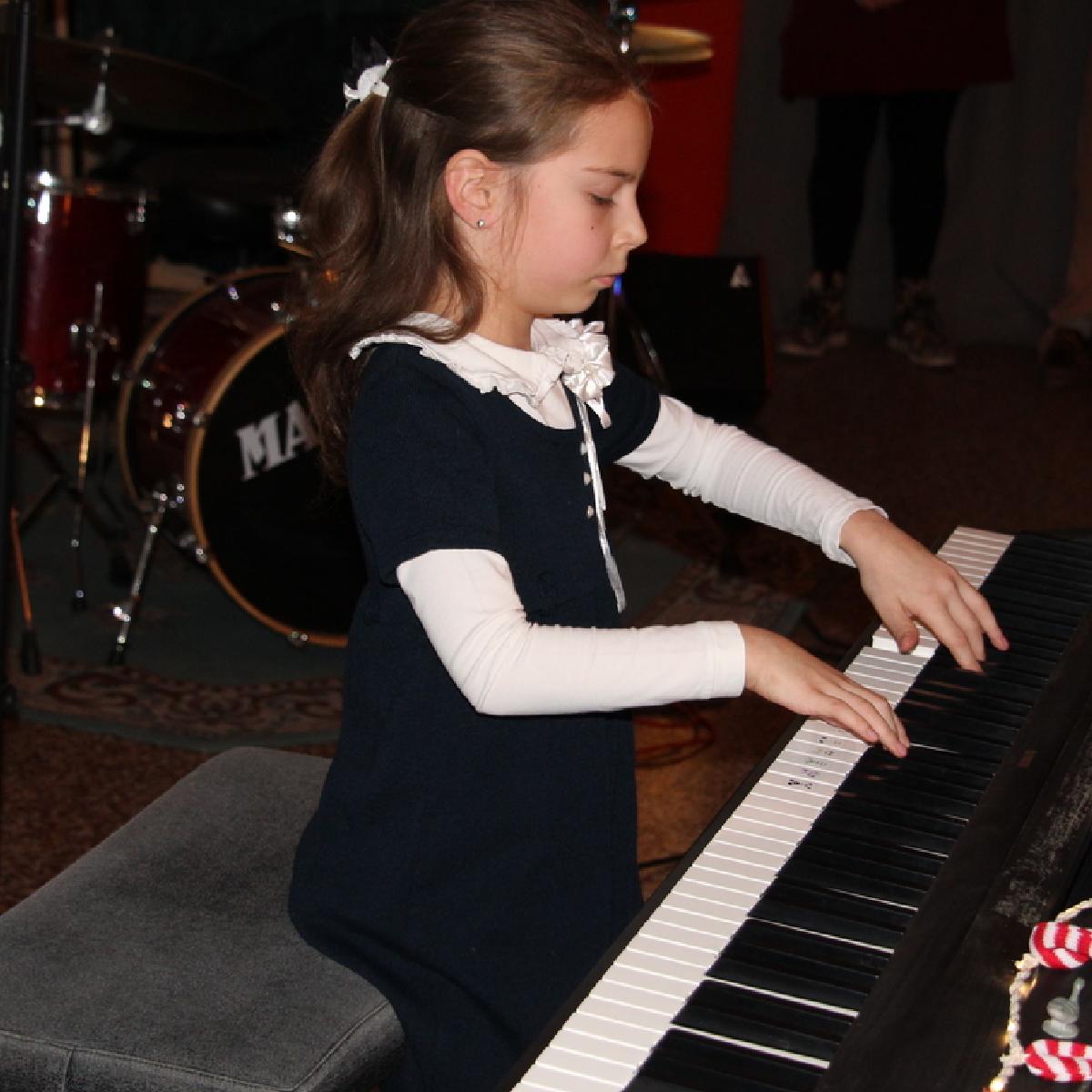 une éléève inscrite à un cours de piano pour enfant à montréal pendant le récital de Musiprof