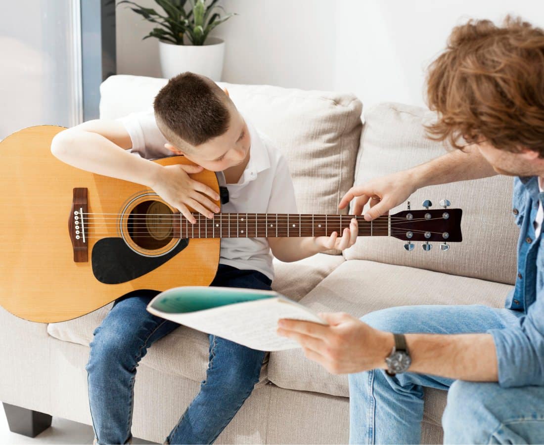 Enfant qui apprend à jouer la guitare