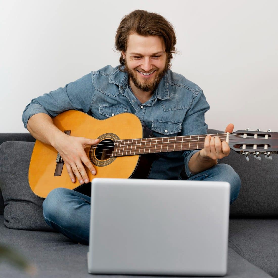 Homme qui suit des cours de guitare en ligne